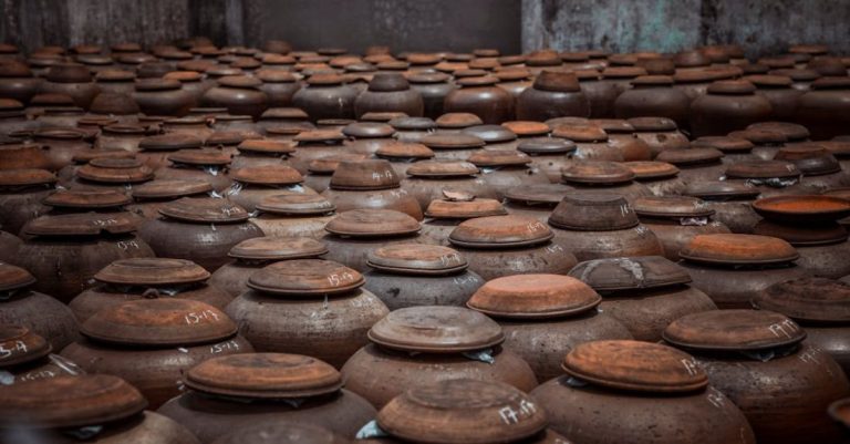 Storage Solutions - A large group of brown clay pots sitting on a table