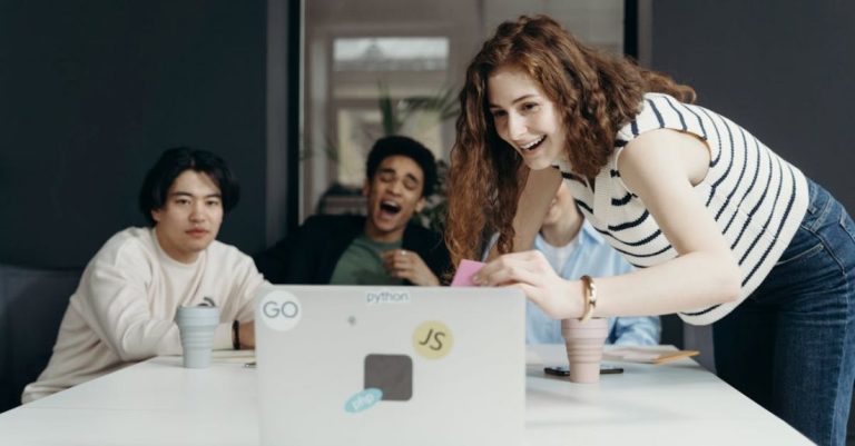 Agile Workspaces - People Laughing Looking at a Laptop